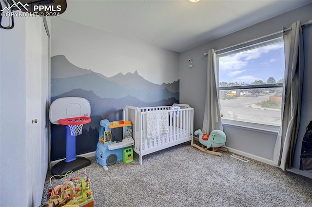 carpeted bedroom featuring a crib