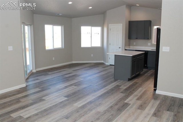 kitchen with lofted ceiling, a center island, and wood-type flooring