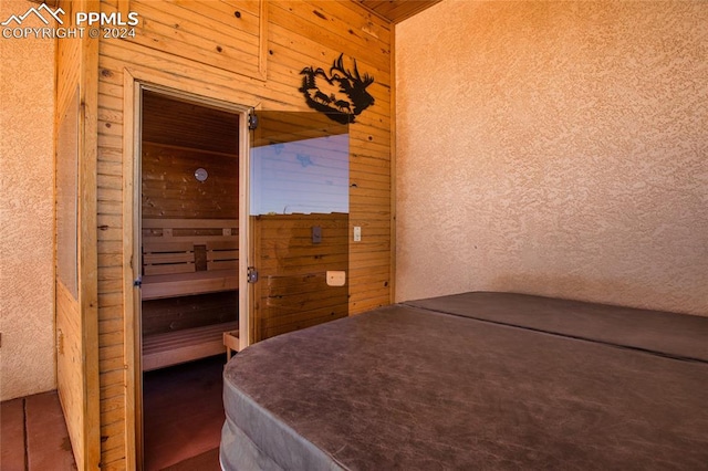 bedroom featuring wooden walls