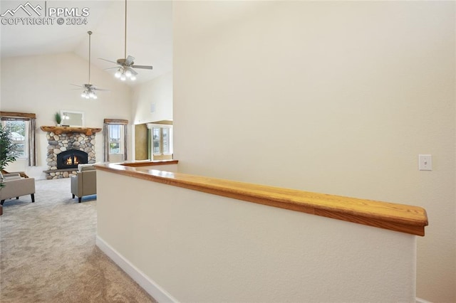 hall with high vaulted ceiling and light colored carpet