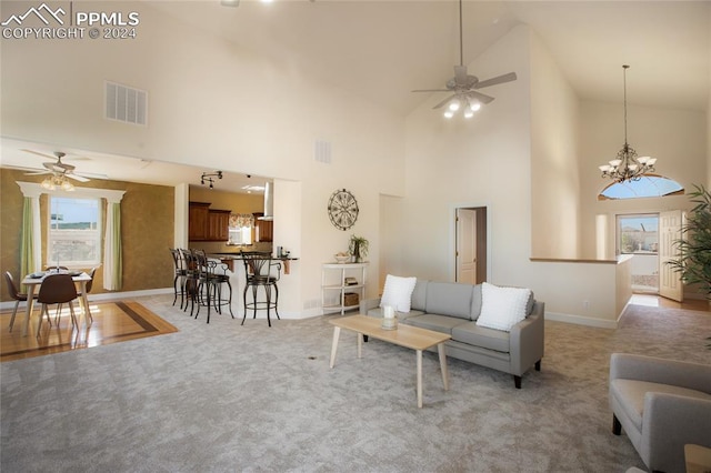 living room featuring light colored carpet, ceiling fan with notable chandelier, and high vaulted ceiling