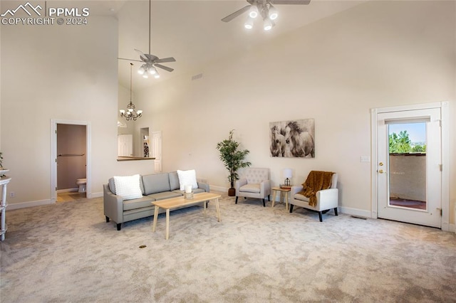 carpeted living room featuring high vaulted ceiling and ceiling fan with notable chandelier