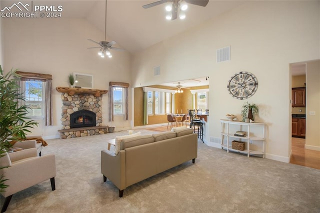 carpeted living room featuring ceiling fan, a fireplace, high vaulted ceiling, and a wealth of natural light