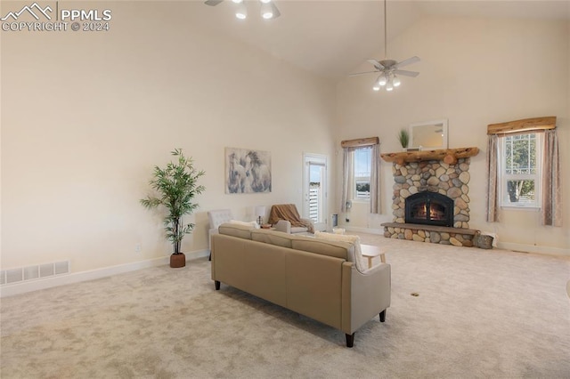 living room with a fireplace, ceiling fan, light colored carpet, and high vaulted ceiling