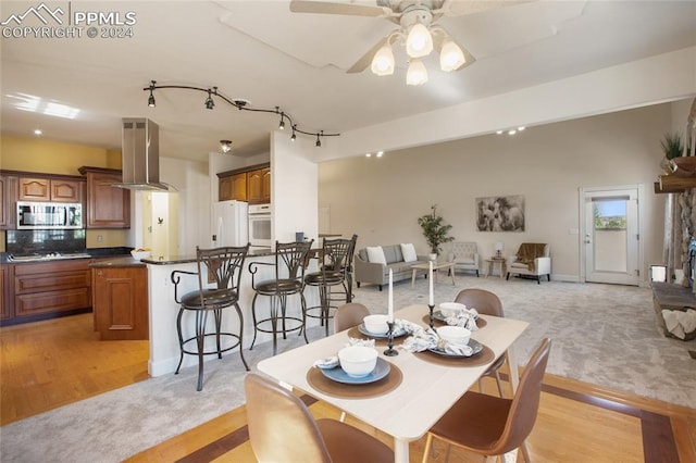 dining space featuring light wood-type flooring and ceiling fan