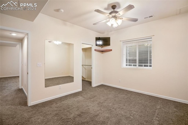 unfurnished bedroom featuring dark colored carpet and ceiling fan