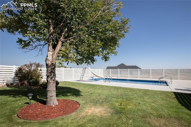 view of swimming pool with a lawn and a water slide