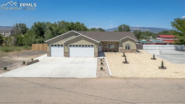 single story home featuring a mountain view and a garage