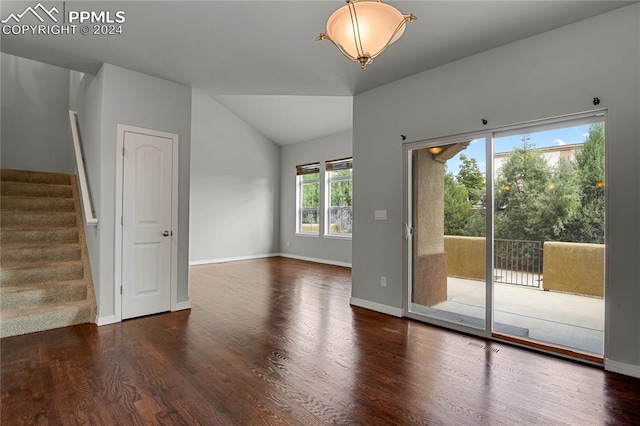 unfurnished room featuring dark hardwood / wood-style floors and vaulted ceiling