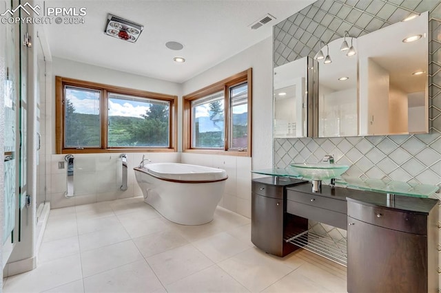 bathroom featuring tile walls, vanity, separate shower and tub, and tile patterned floors