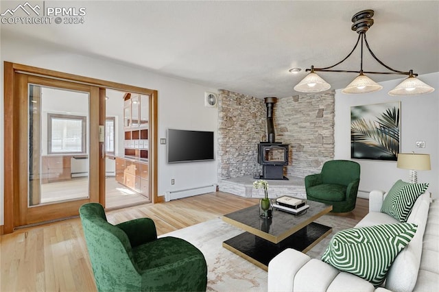 living room featuring a baseboard radiator, a wood stove, and hardwood / wood-style floors