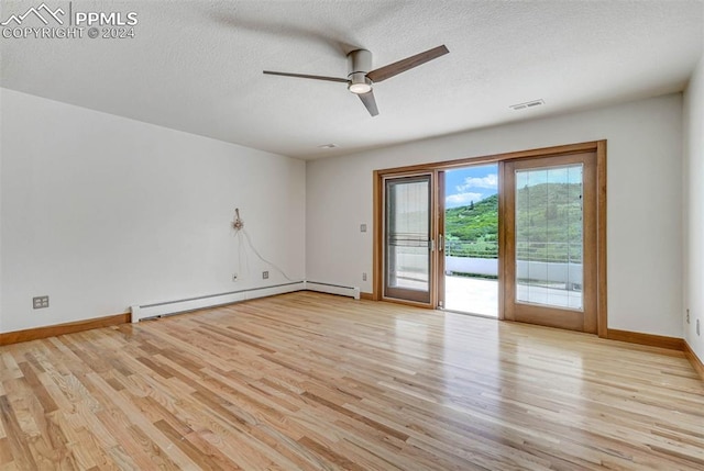 empty room featuring ceiling fan, a baseboard radiator, light hardwood / wood-style floors, and a textured ceiling