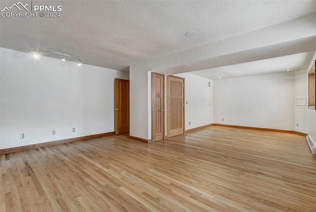 empty room featuring light hardwood / wood-style flooring and a textured ceiling