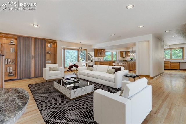 living room featuring light hardwood / wood-style floors and an inviting chandelier