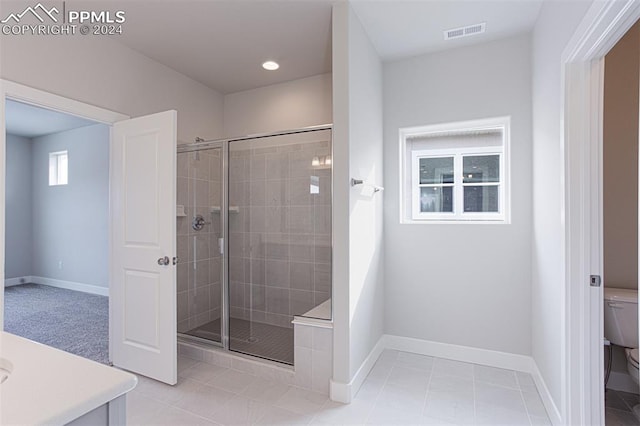 bathroom with vanity, toilet, an enclosed shower, and tile patterned floors