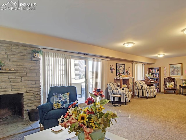 living room with carpet and a stone fireplace