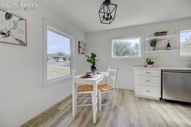 2459 E Willamette Ave, Colorado Springs, CO 80909 - dining area with light wood-type flooring, a dry bar, baseboards, and a notable chandelier