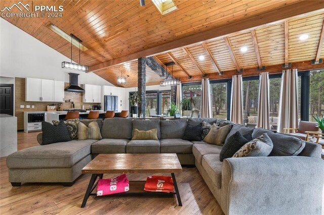 living room with wooden ceiling, vaulted ceiling with skylight, and light hardwood / wood-style floors