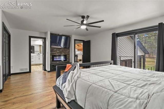 bedroom featuring light wood-type flooring, ceiling fan, access to outside, and ensuite bath