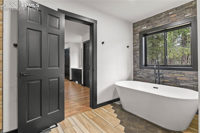 bathroom featuring a washtub and hardwood / wood-style flooring