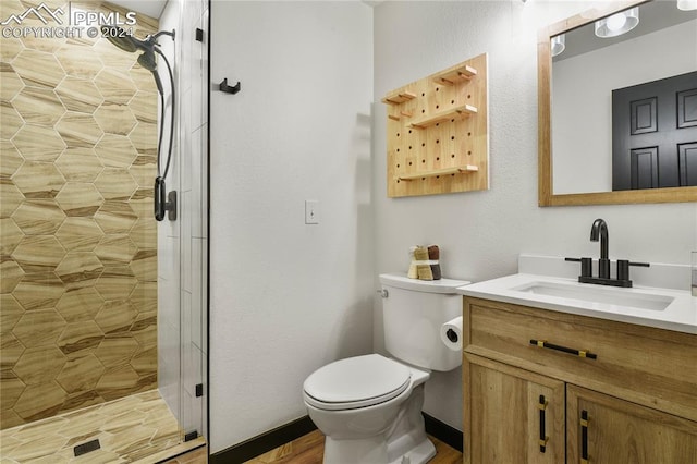 bathroom featuring a shower with door, vanity, toilet, and hardwood / wood-style floors