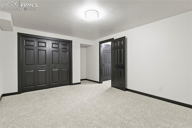 unfurnished bedroom with a closet, carpet flooring, and a textured ceiling