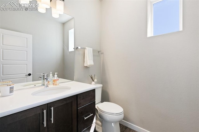 bathroom with vanity, toilet, and hardwood / wood-style floors