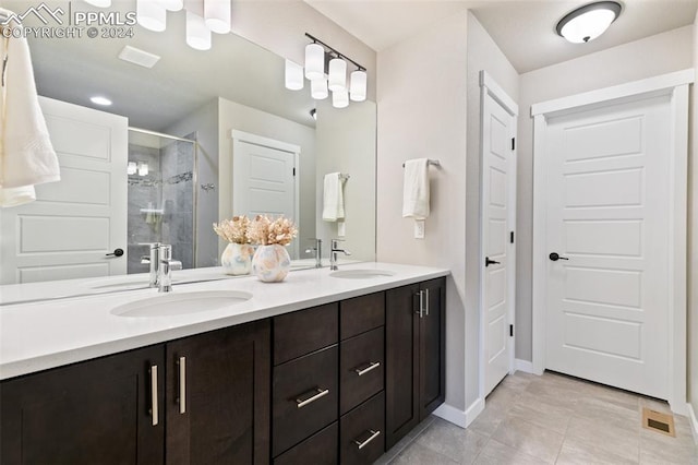 bathroom featuring a shower with shower door, tile patterned flooring, and vanity