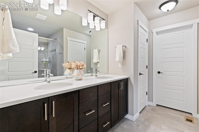 bathroom featuring tile patterned flooring, vanity, and walk in shower