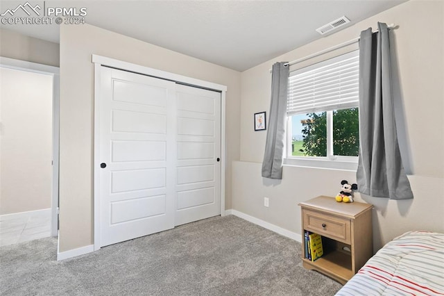 bedroom featuring a closet and light colored carpet