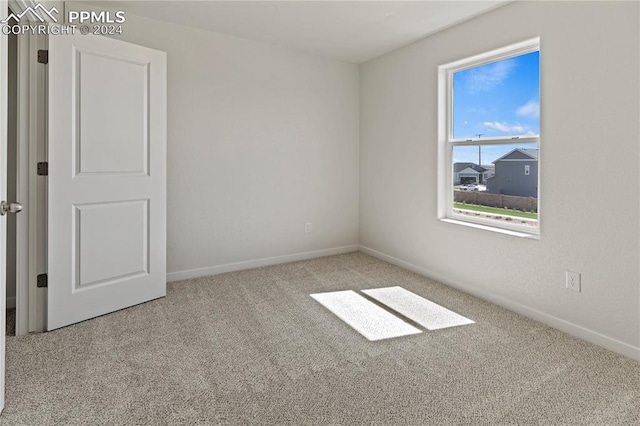 unfurnished room featuring light colored carpet