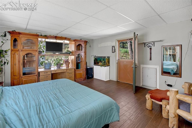 bedroom with dark wood-type flooring and a paneled ceiling