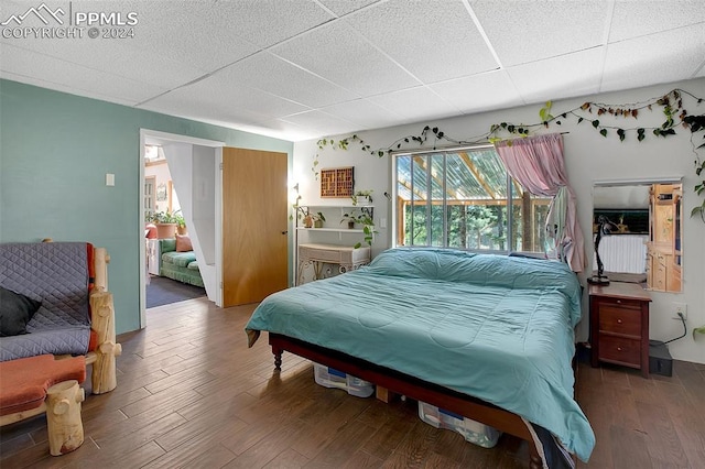 bedroom featuring a paneled ceiling, dark hardwood / wood-style floors, and ensuite bathroom