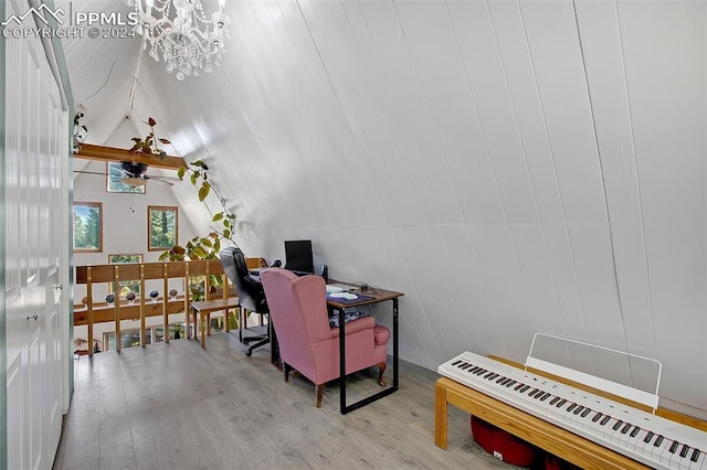 office space with wood walls, an inviting chandelier, radiator, high vaulted ceiling, and light wood-type flooring