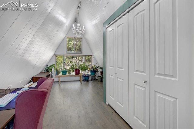 interior space with vaulted ceiling, a notable chandelier, and light wood-type flooring