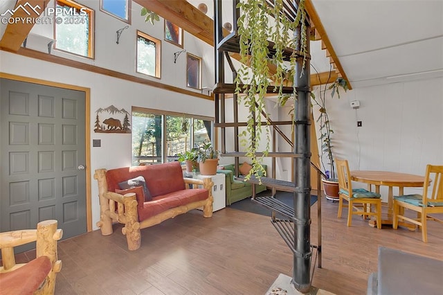 living room with plenty of natural light, a towering ceiling, and hardwood / wood-style flooring