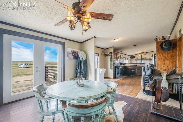 dining area with ceiling fan, a textured ceiling, light hardwood / wood-style flooring, and french doors