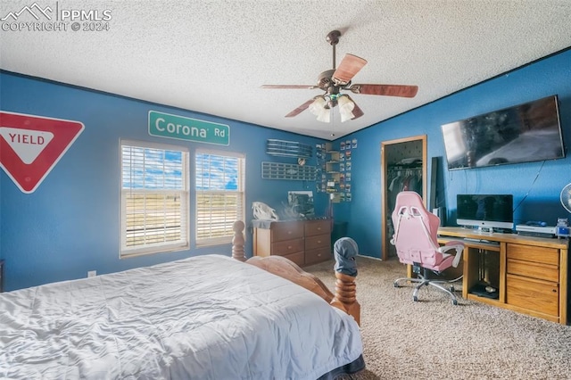 carpeted bedroom with a spacious closet, a closet, ceiling fan, and a textured ceiling