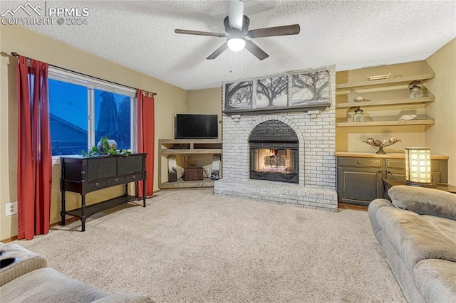 carpeted living room with a textured ceiling, ceiling fan, and a brick fireplace