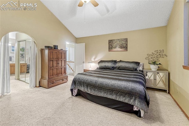 carpeted bedroom with a textured ceiling, connected bathroom, ceiling fan, and high vaulted ceiling