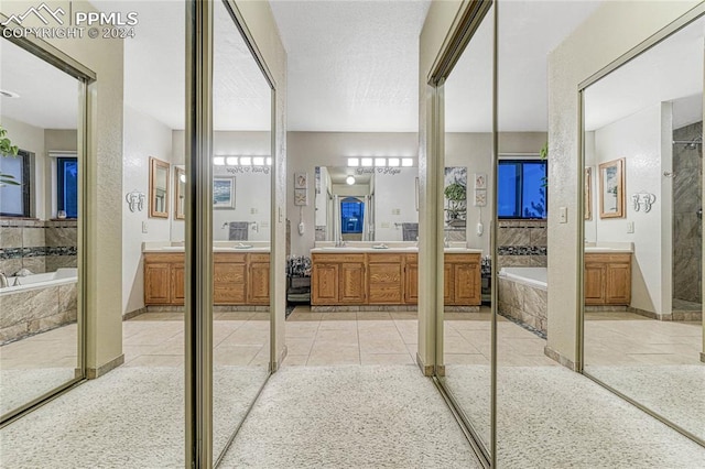 bathroom with plus walk in shower, tile patterned floors, and vanity