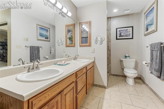 bathroom featuring tile patterned flooring, walk in shower, vanity, and toilet