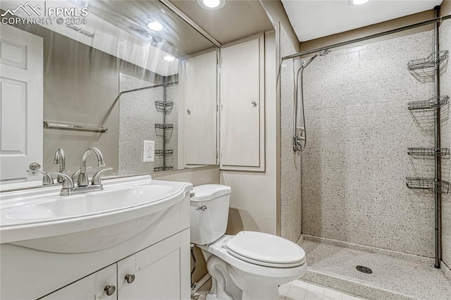 bathroom featuring vanity, toilet, and tiled shower