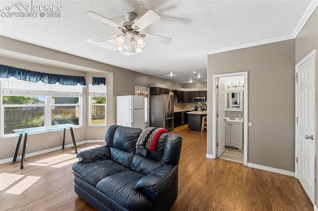 living room with a textured ceiling, ceiling fan, hardwood / wood-style floors, and crown molding