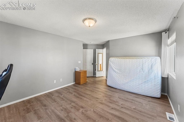 unfurnished bedroom featuring light hardwood / wood-style floors and a textured ceiling