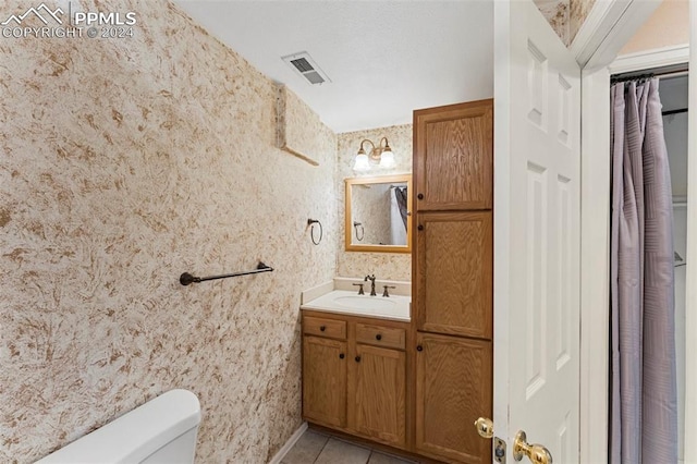 bathroom with tile patterned flooring, vanity, and toilet