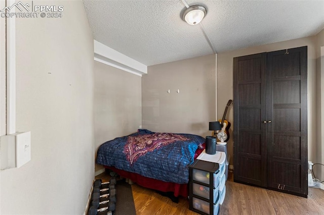 bedroom featuring a textured ceiling and hardwood / wood-style floors