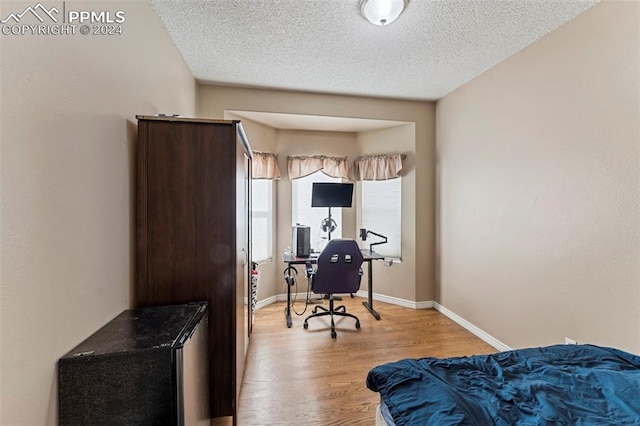 office space featuring a textured ceiling and light hardwood / wood-style flooring