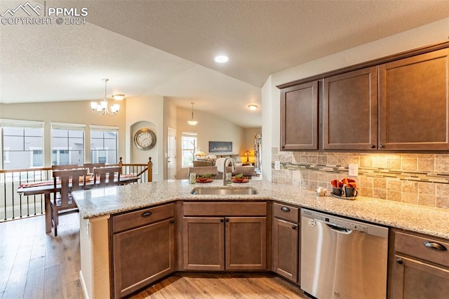 kitchen with lofted ceiling, dishwasher, sink, and light hardwood / wood-style floors