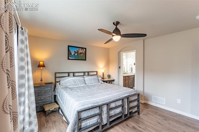 bedroom with light hardwood / wood-style flooring, connected bathroom, and ceiling fan